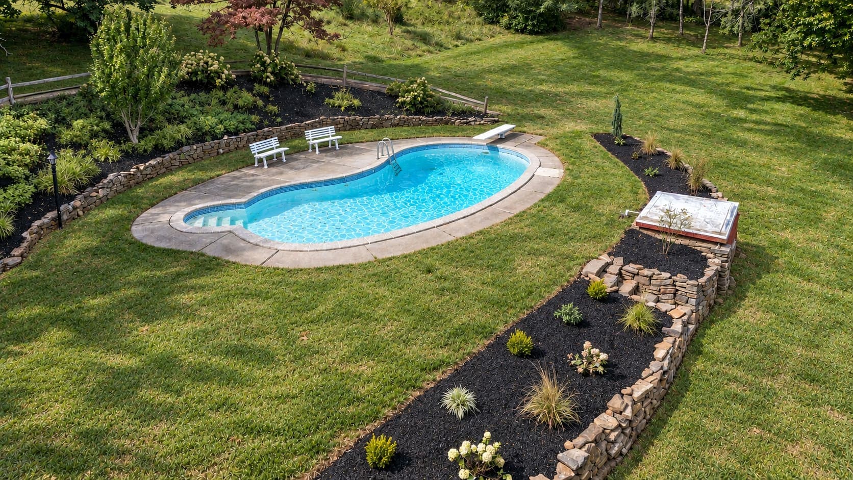 The in-ground pool from above, with new stone-edged garden beds